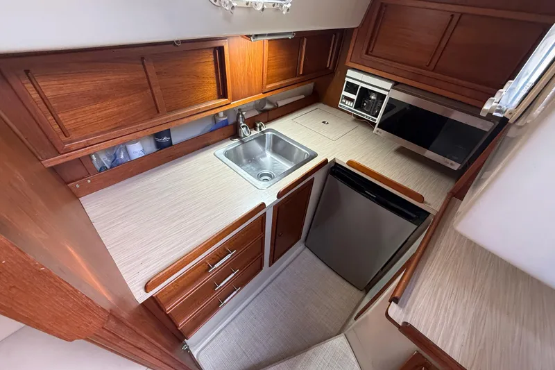 Slide: The Image of 1977 Irwin 37 Mark III yacht kitchen with wood cabinets, sink, and appliances. - 33
