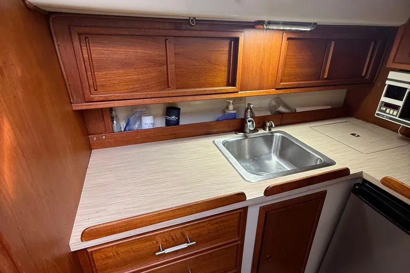 Slide: The Image of 1977 Irwin 37 Mark III yacht kitchen with wooden cabinets and stainless steel sink. - 34