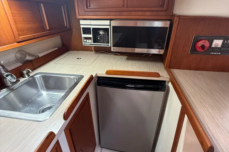 Slide: The Image of 1977 Irwin 37 Mark III yacht kitchen with sink, microwave, and fridge. - 36