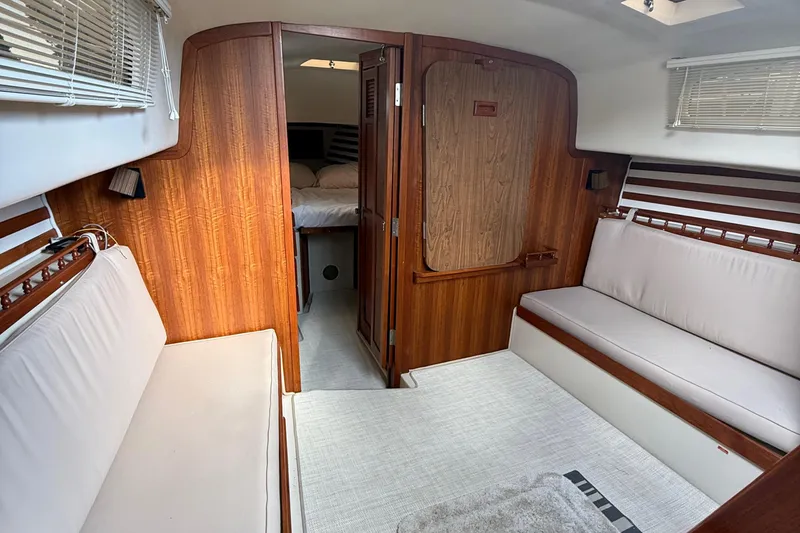 Slide: The Image of Interior of 1977 Irwin 37 Mark III sailboat with wood paneling and cushioned seating. - 37