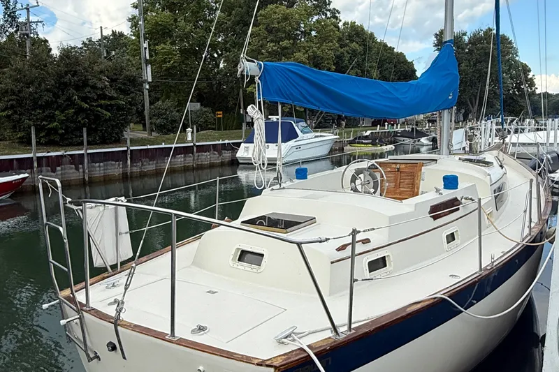 Slide: The Image of 1977 Irwin 37 Mark III sailboat docked, featuring blue sail cover and wooden accents. - 4