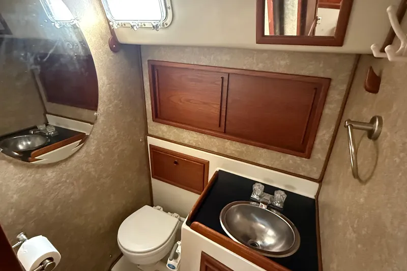 Slide: The Image of 1977 Irwin 37 Mark III yacht bathroom with sink, toilet, and wooden cabinets. - 42