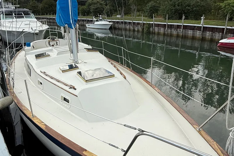Slide: The Image of 1977 Irwin 37 Mark III sailboat docked in a serene marina setting. - 5