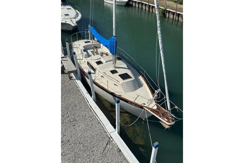 Slide: The Image of 1977 Irwin 37 Mark III sailboat docked in a marina, featuring blue sail cover. - 55