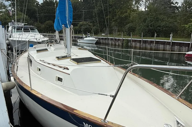 Slide: The Image of 1977 Irwin 37 Mark III sailboat docked in a serene marina setting. - 6