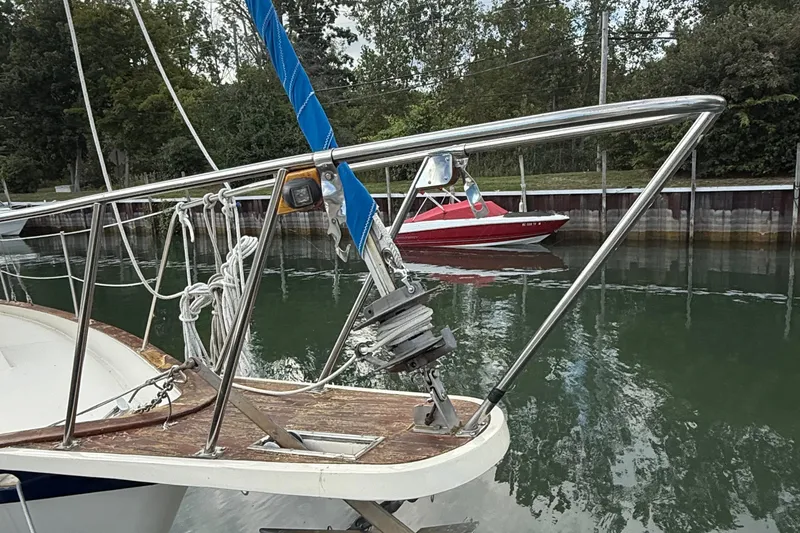 Slide: The Image of 1977 Irwin 37 Mark III sailboat bow with anchor, docked near a red motorboat. - 8