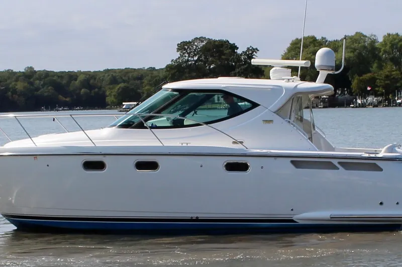Slide: The Image of 2008 Tiara Yachts 3500 Sovran cruising on a calm lake with forested shoreline. - 10