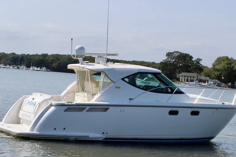 Slide: The Image of 2008 Tiara Yachts 3500 Sovran cruising on a calm lake with scenic background. - 2