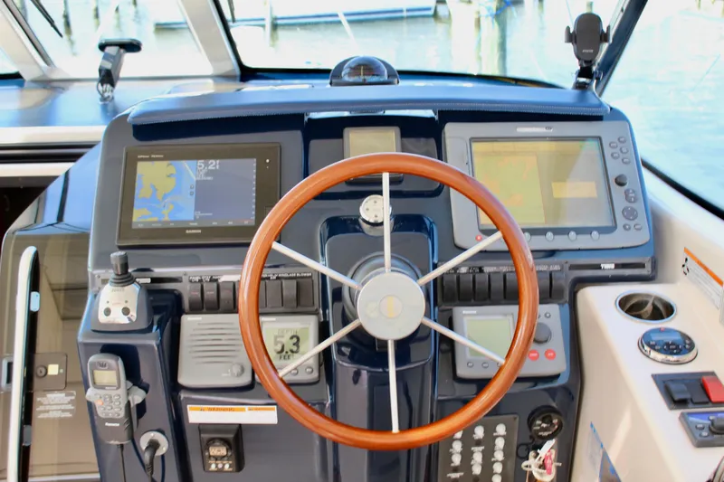 Slide: The Image of 2008 Tiara Yachts 3500 Sovran helm with navigation displays and wooden steering wheel. - 24