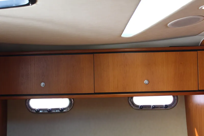 Slide: The Image of 2008 Tiara Yachts 3500 Sovran interior with wooden cabinets and porthole windows. - 35