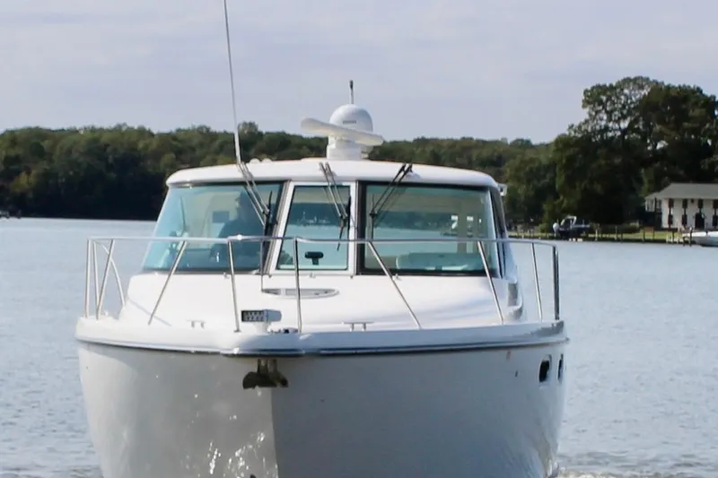 Slide: The Image of 2008 Tiara Yachts 3500 Sovran cruising on a calm lake with trees in the background. - 8