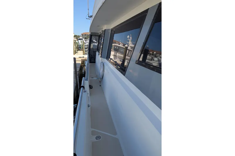 Slide: The Image of Side deck of 1992 Viking 65 Motor Yacht, featuring sleek design and reflective windows. - 19