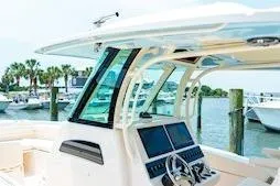 Slide: The Image of 2026 Grady-White Canyon 306 boat at marina, featuring modern helm and dual screens. - 11