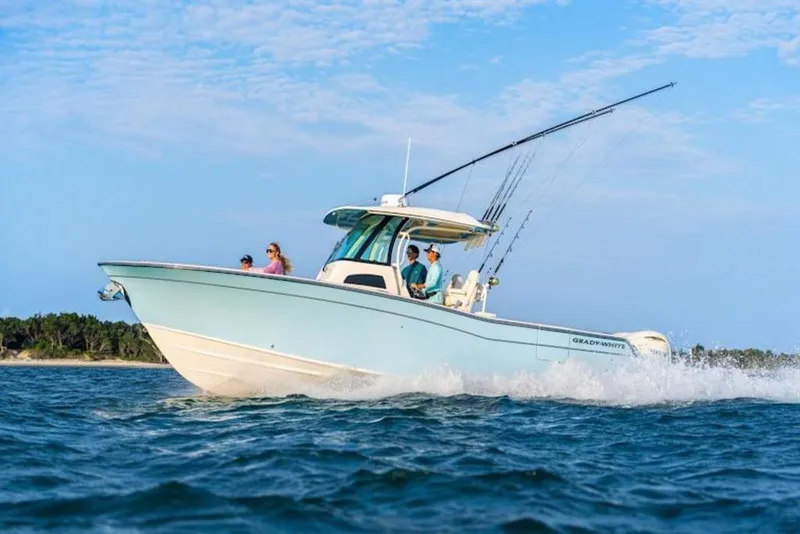 The Image of 2026 Grady-White Canyon 306 boat cruising on open water with fishing rods. - 2