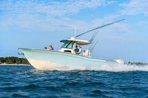 Slide: The Image of 2026 Grady-White Canyon 306 boat cruising on open water under a clear blue sky. - 5