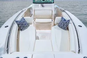Slide: The Image of 2026 Grady-White Canyon 306 boat interior with cushioned seating and decorative pillows. - 7