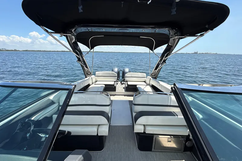 Slide: The Image of 2017 Regal 29 OBX boat interior with seating, canopy, and ocean view. - 12