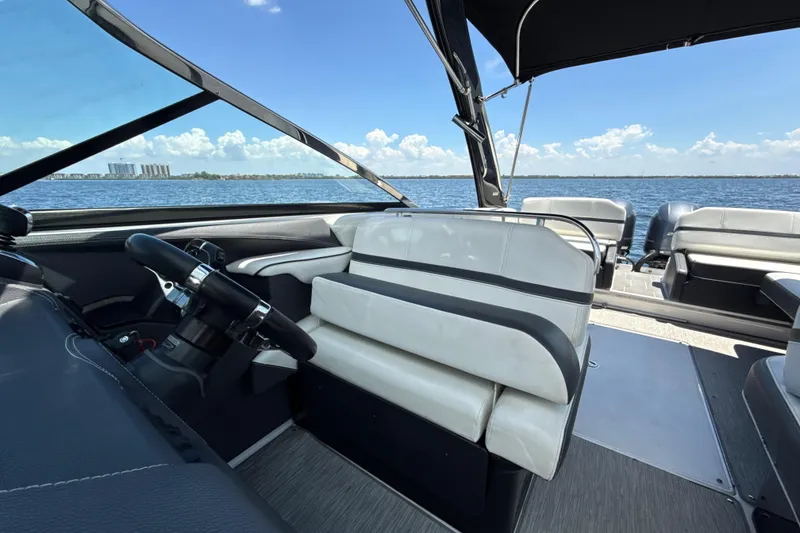 Slide: The Image of 2017 Regal 29 OBX boat interior with steering wheel, seating, and ocean view. - 14