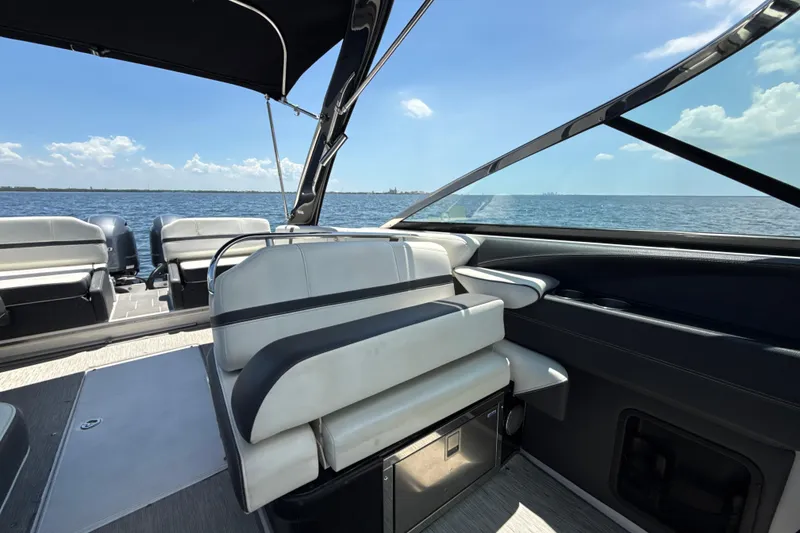 Slide: The Image of 2017 Regal 29 OBX boat interior with seating, overlooking calm ocean and blue sky. - 15