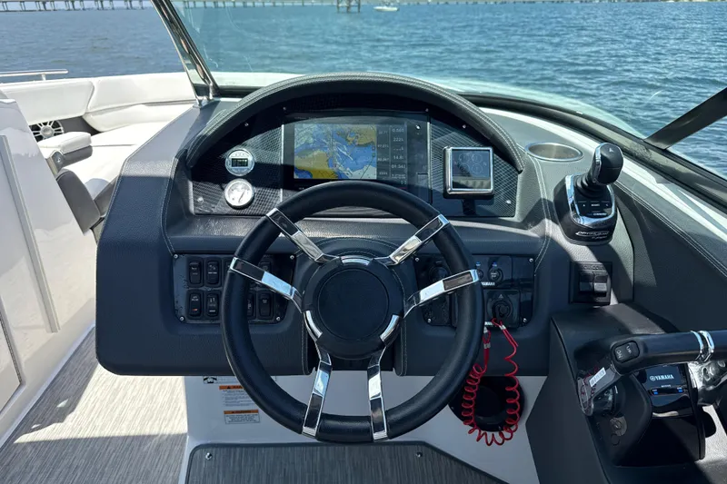 Slide: The Image of 2017 Regal 29 OBX boat dashboard with steering wheel and navigation controls. - 2