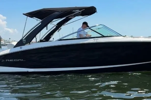 Slide: The Image of 2017 Regal 29 OBX boat on water with black canopy and sleek design. - 24
