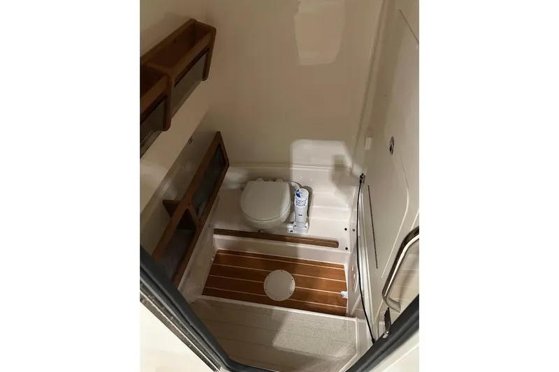 Slide: The Image of 2026 Grady-White Canyon 271 boat interior bathroom with wooden flooring and storage shelves. - 20