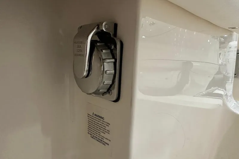 Slide: The Image of 2026 Grady-White Canyon 271 boat power outlet with safety warning label. - 21