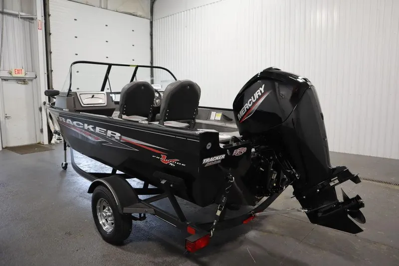 Slide: The Image of 2023 Tracker Pro Guide V-16 WT boat with Mercury engine in a garage setting. - 11