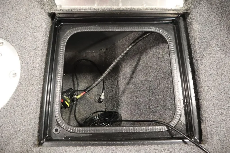 Slide: The Image of 2023 Tracker Pro Guide V-16 WT storage compartment with wiring and carpeted interior. - 22