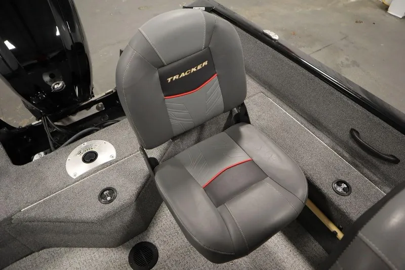 Slide: The Image of 2023 Tracker Pro Guide V-16 WT boat seat, gray with red accents, in a carpeted interior. - 39