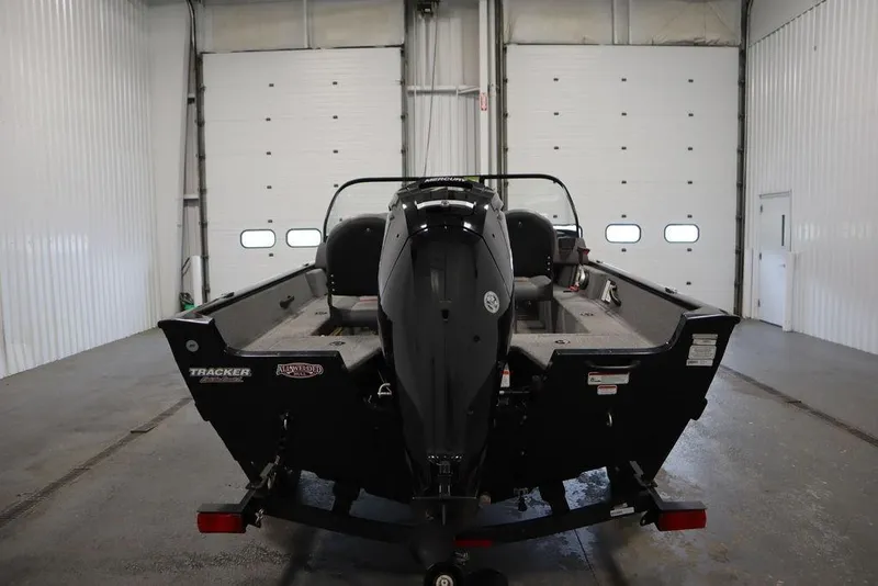 Slide: The Image of 2023 Tracker Pro Guide V-16 WT boat in a garage, rear view. - 6