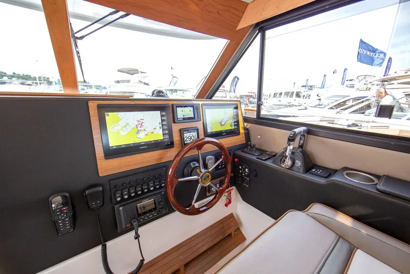 Slide: The Image of 2026 Cutwater C-32 CB helm with navigation screens and steering wheel, showcasing modern boat technology. - 7