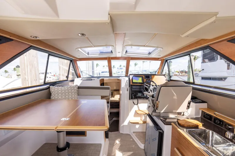 Slide: The Image of Interior of 2026 Cutwater C-288 C boat, featuring helm, seating, and kitchenette. - 7
