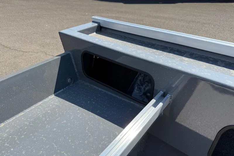 Slide: The Image of 2026 Fish Rite Angler 18 boat detail, showing storage compartment and rail system. - 13