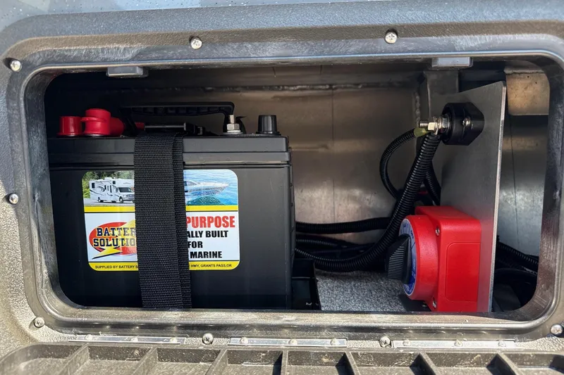 Slide: The Image of Battery compartment of 2026 Fish Rite Angler 18 boat, featuring marine battery and wiring. - 16