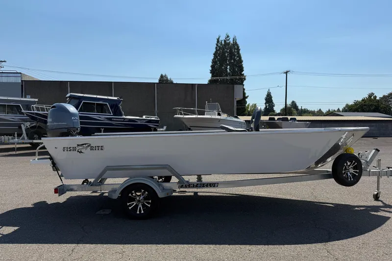 Slide: The Image of 2026 Fish Rite Angler 18 boat on trailer, parked outdoors under clear sky. - 4