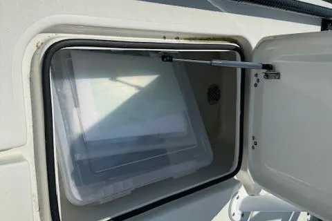 Slide: The Image of 2024 Beavertail Skiffs Vengeance storage compartment with open hatch and visible container. - 22
