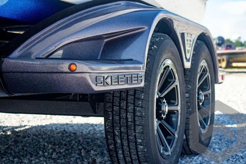 Slide: The Image of 2026 Skeeter FXR21 FLEX trailer with dual black wheels on gravel. - 19
