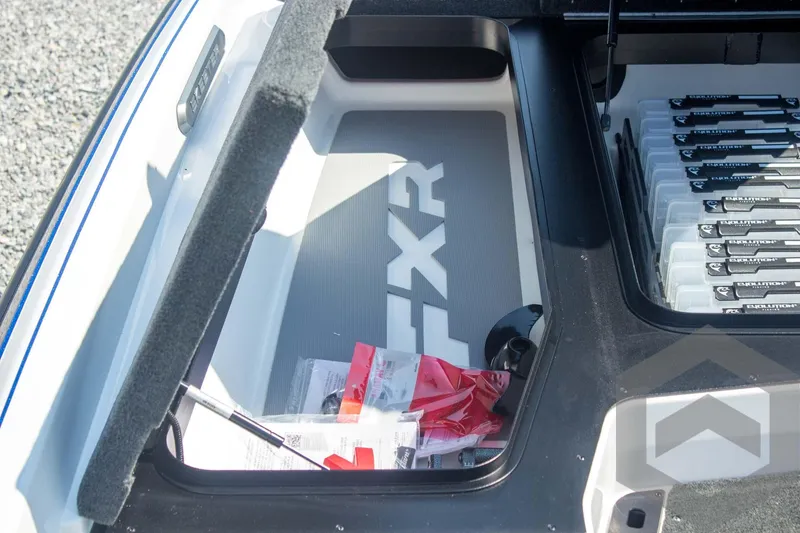 Slide: The Image of Storage compartment of 2026 Skeeter FXR21 FLEX boat with organized tackle boxes. - 29