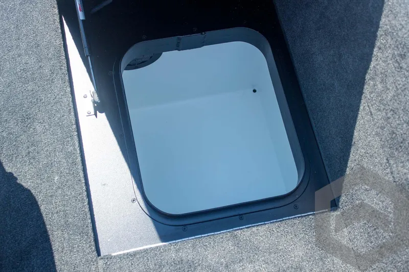 Slide: The Image of 2026 Skeeter FXR21 FLEX boat storage compartment with open hatch, featuring carpeted interior. - 42