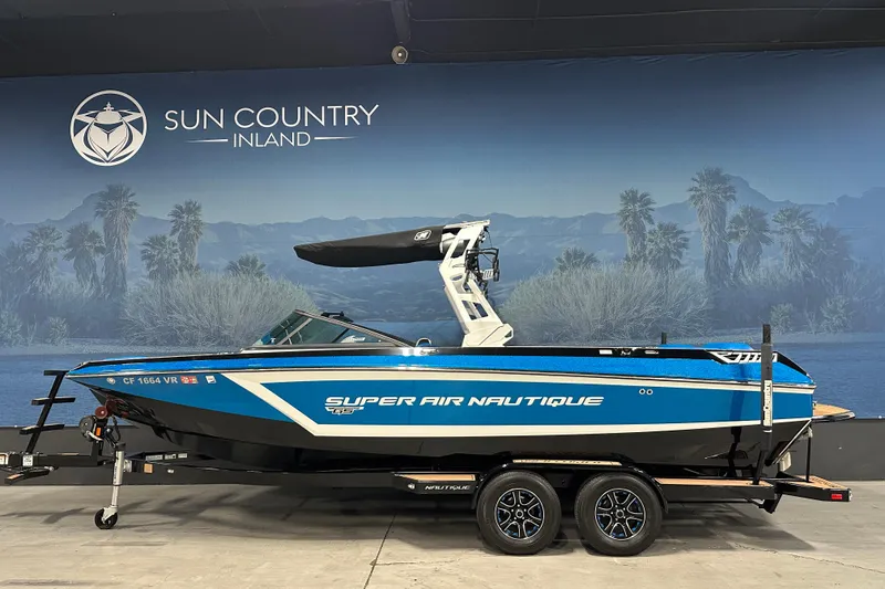 The Image of 2018 Nautique Super Air Nautique GS24 boat on trailer, displayed indoors. - 0