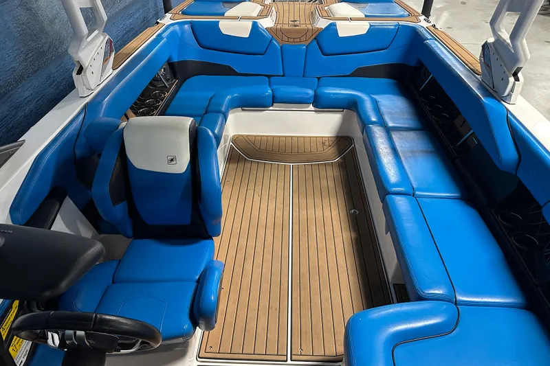 Slide: The Image of 2018 Nautique Super Air Nautique GS24 interior with blue seating and wooden flooring. - 10