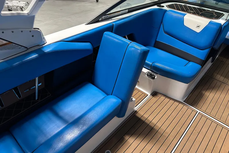 Slide: The Image of 2018 Nautique Super Air Nautique GS24 interior with blue seating and wooden flooring. - 11