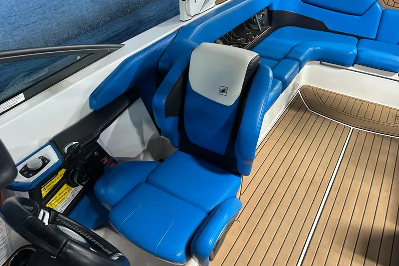 Slide: The Image of 2018 Nautique Super Air Nautique GS24 interior with blue seating and wood flooring. - 14