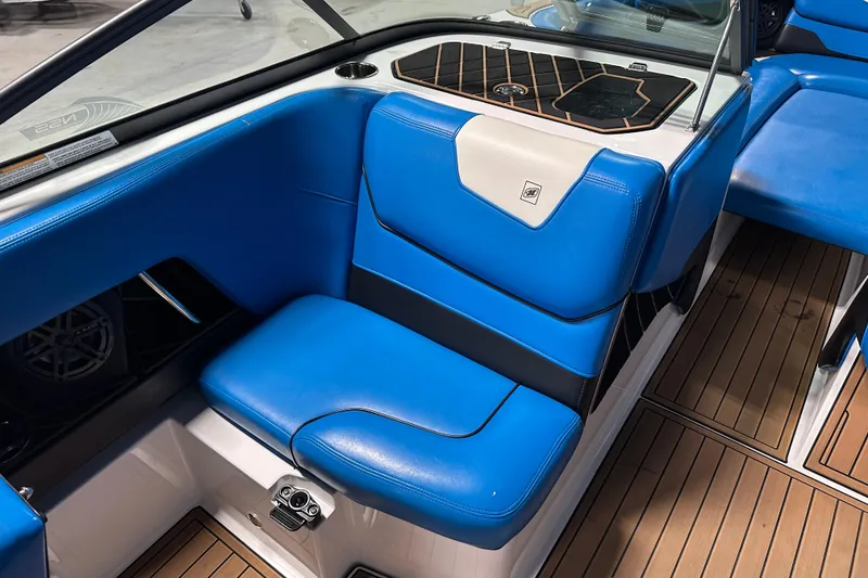 Slide: The Image of 2018 Nautique Super Air Nautique GS24 interior with blue seating and teak flooring. - 16