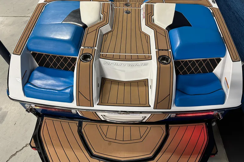 Slide: The Image of 2018 Nautique Super Air Nautique GS24 boat with blue seating and teak-style decking. - 5