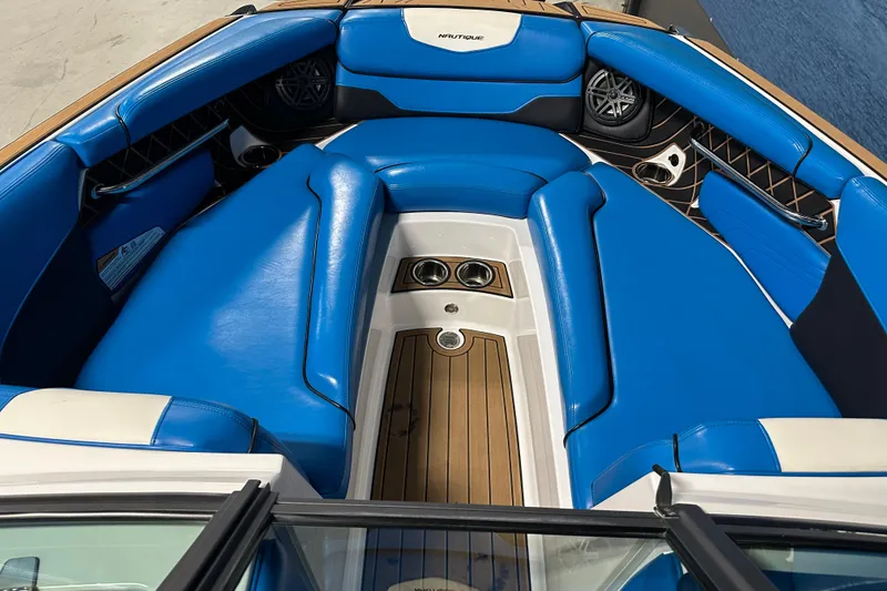 Slide: The Image of 2018 Nautique Super Air Nautique GS24 boat interior with blue seating and teak flooring. - 8
