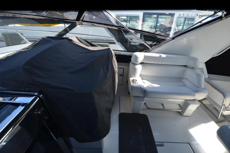 Slide: The Image of Interior of a 1991 Baron 43-E yacht with white seating and covered equipment. - 13