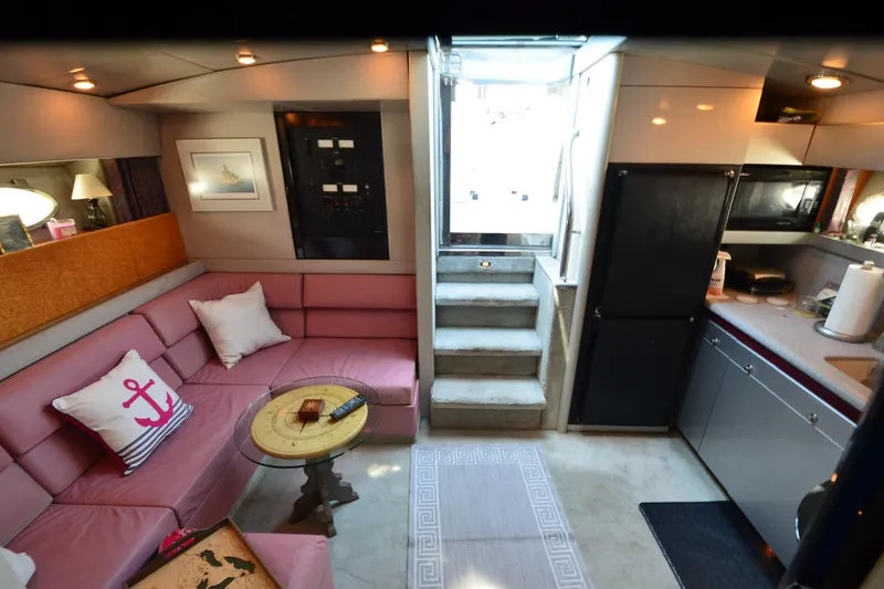 Slide: The Image of Luxurious 1991 Baron 43-E yacht interior with pink seating, kitchenette, and nautical decor. - 18