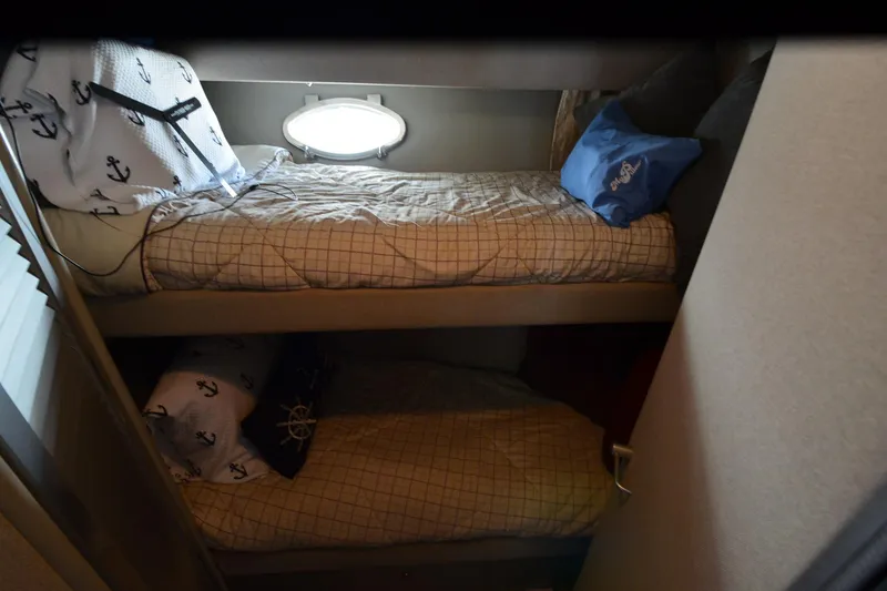 Slide: The Image of Bunk beds in a 1991 Baron 43-E boat cabin with nautical-themed bedding. - 19
